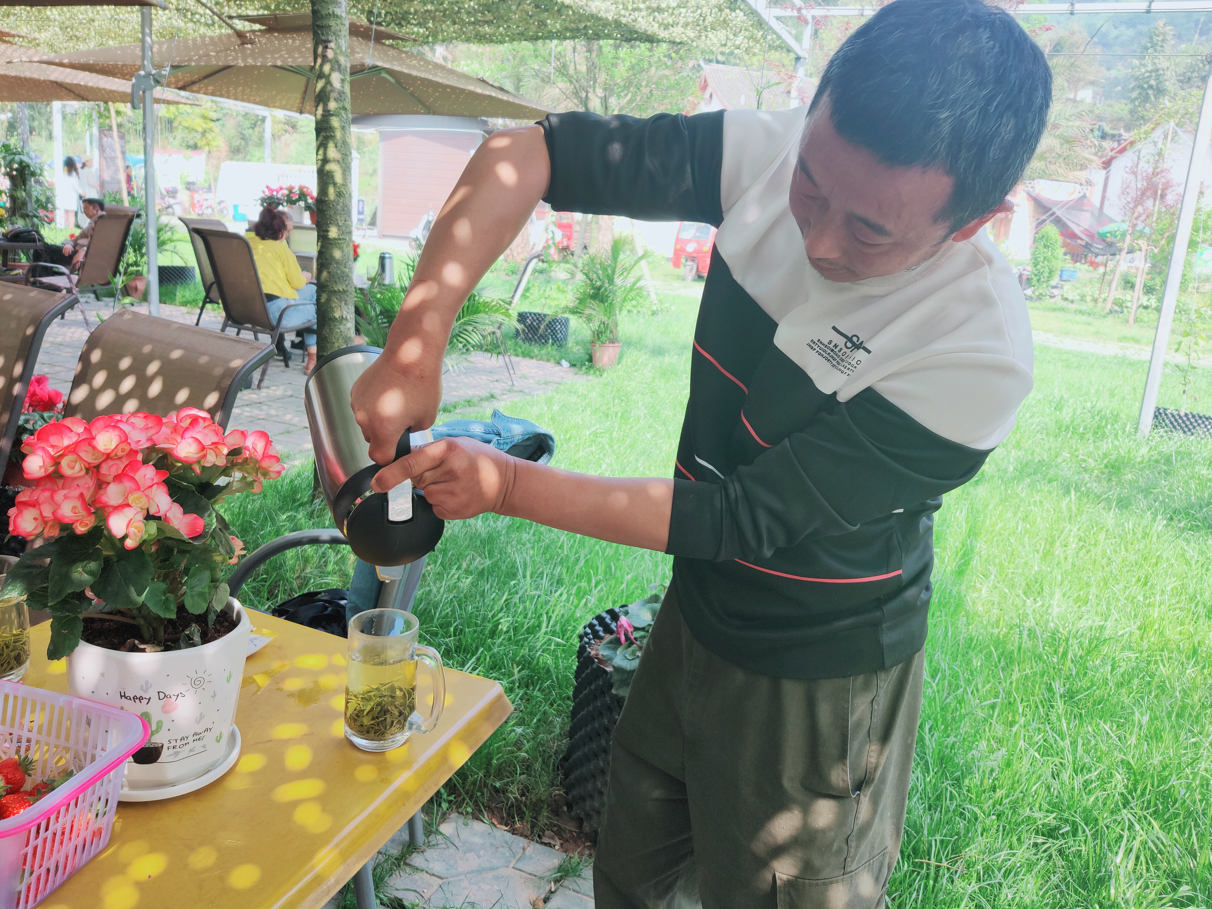 张发平为来农庄的游客倒茶。.jpg