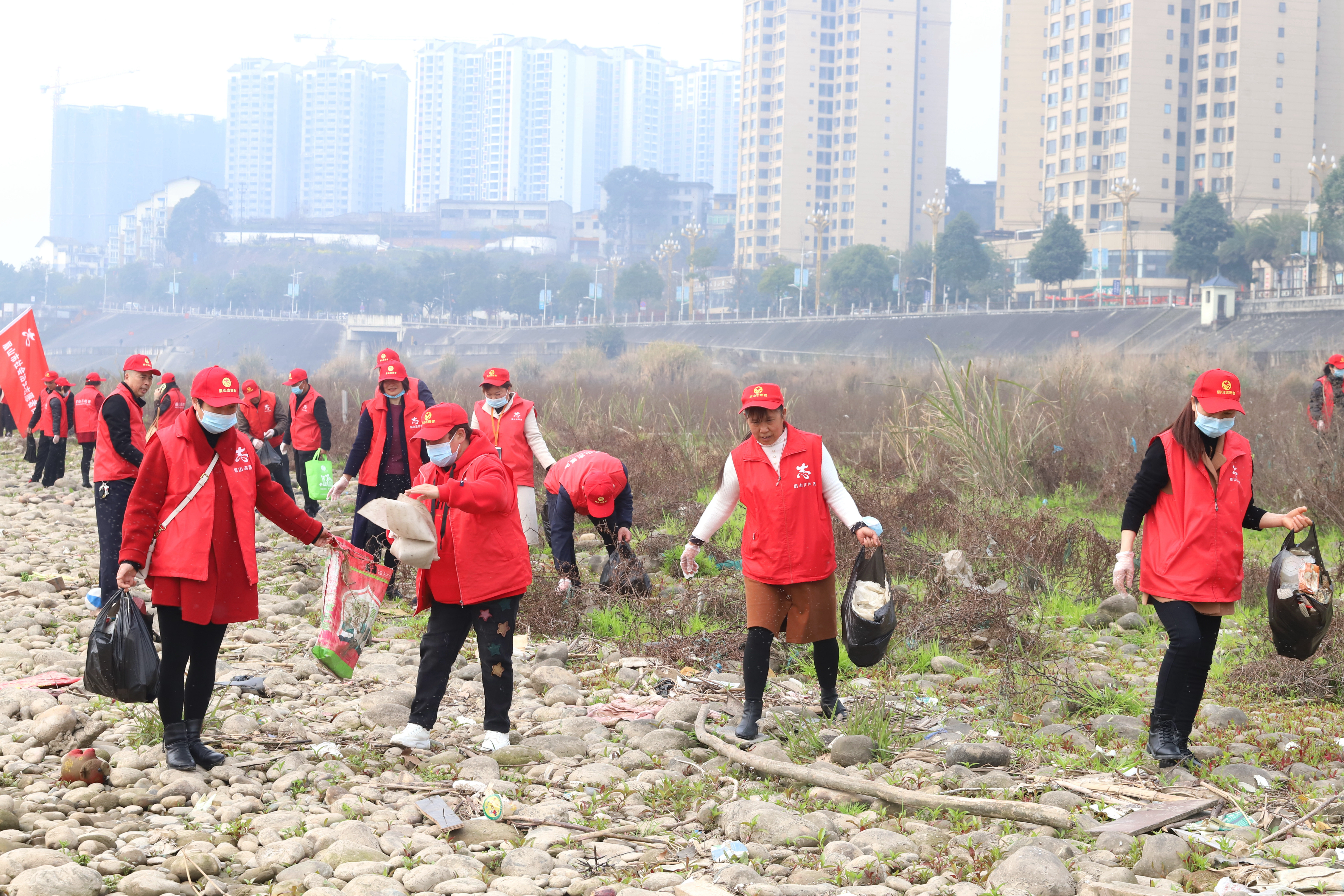 4.志愿者在河边捡垃圾。.JPG